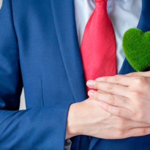 Ejecutivo sujetando corazón hecho con césped