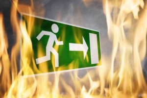 Cartel de salida de emergencia rodeado de llamas