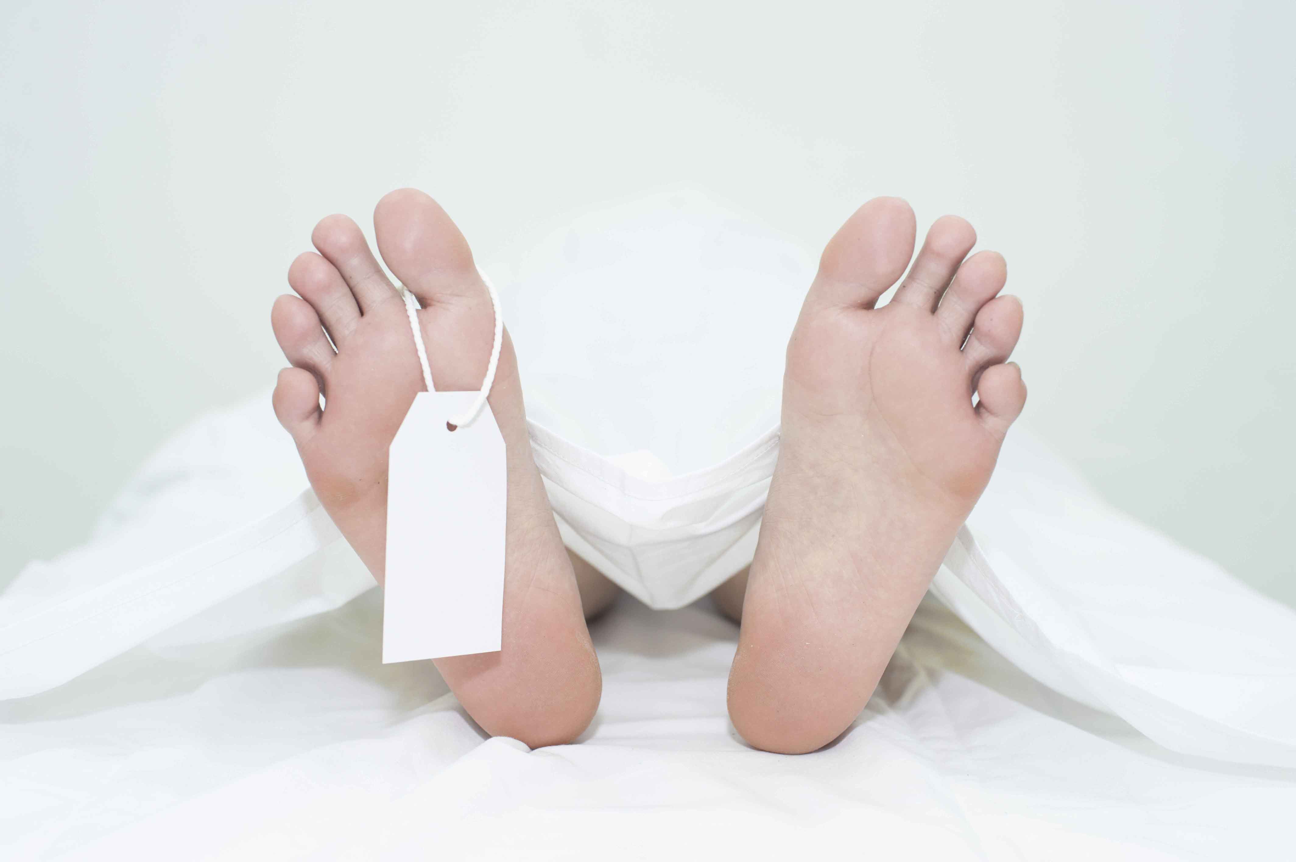 pies de un cadáver tapado con sábana