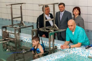 Chico discapacitado rehabilitándose en una piscina