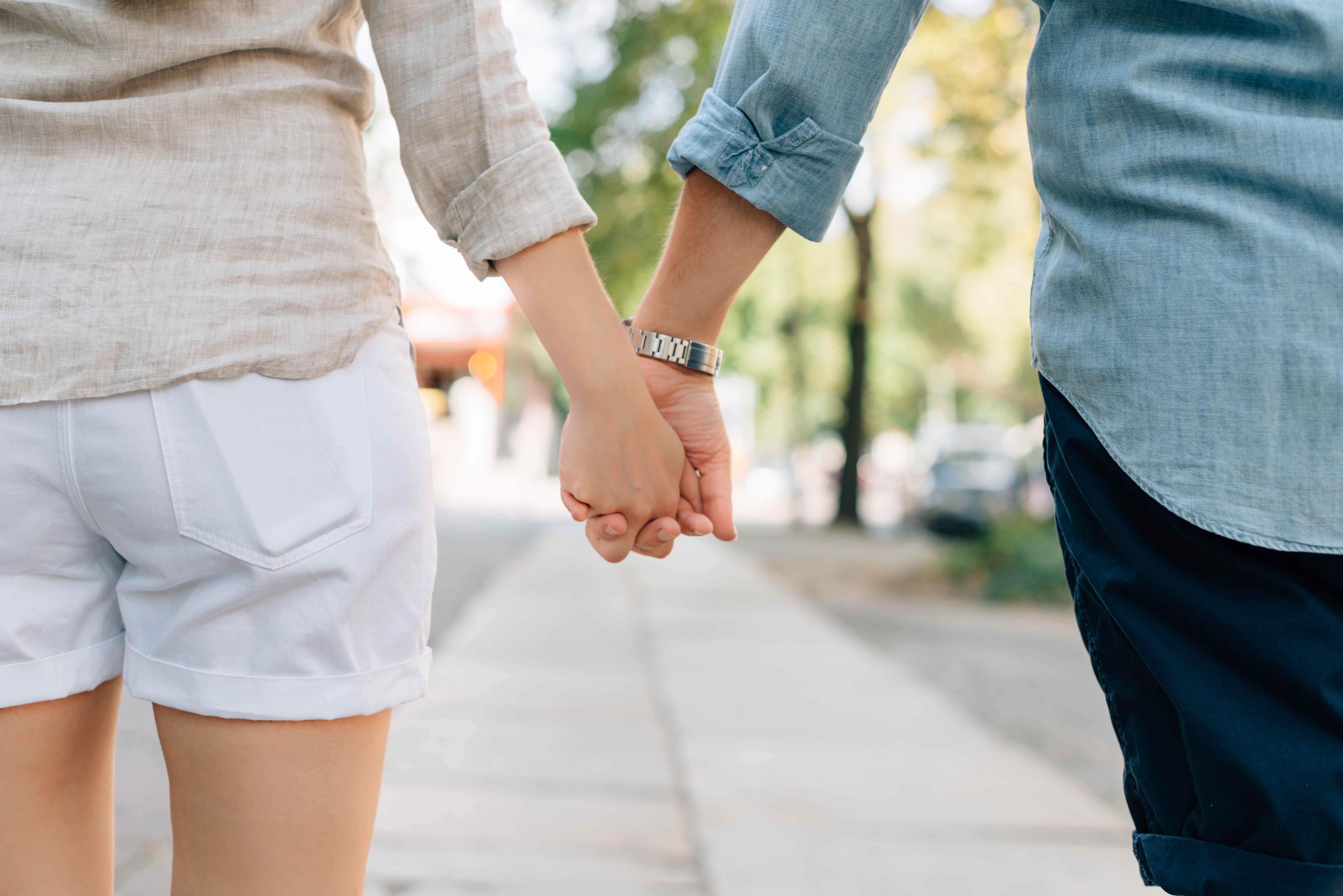Pareja de espaldas caminando cogida por las manos