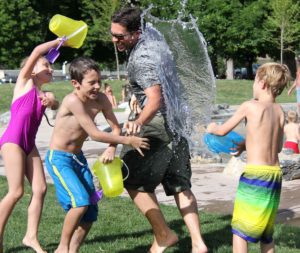 Niños jugando a tirar agua a un monitor