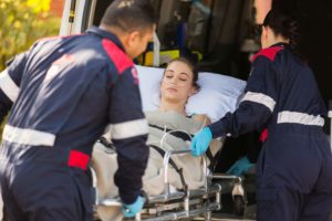 Paciente incosnciente siendo subida a ambulancia