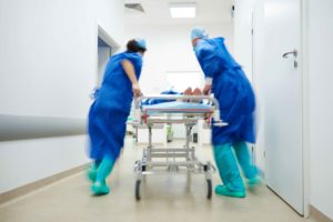Doctores llevando paciente en camilla por pasillo