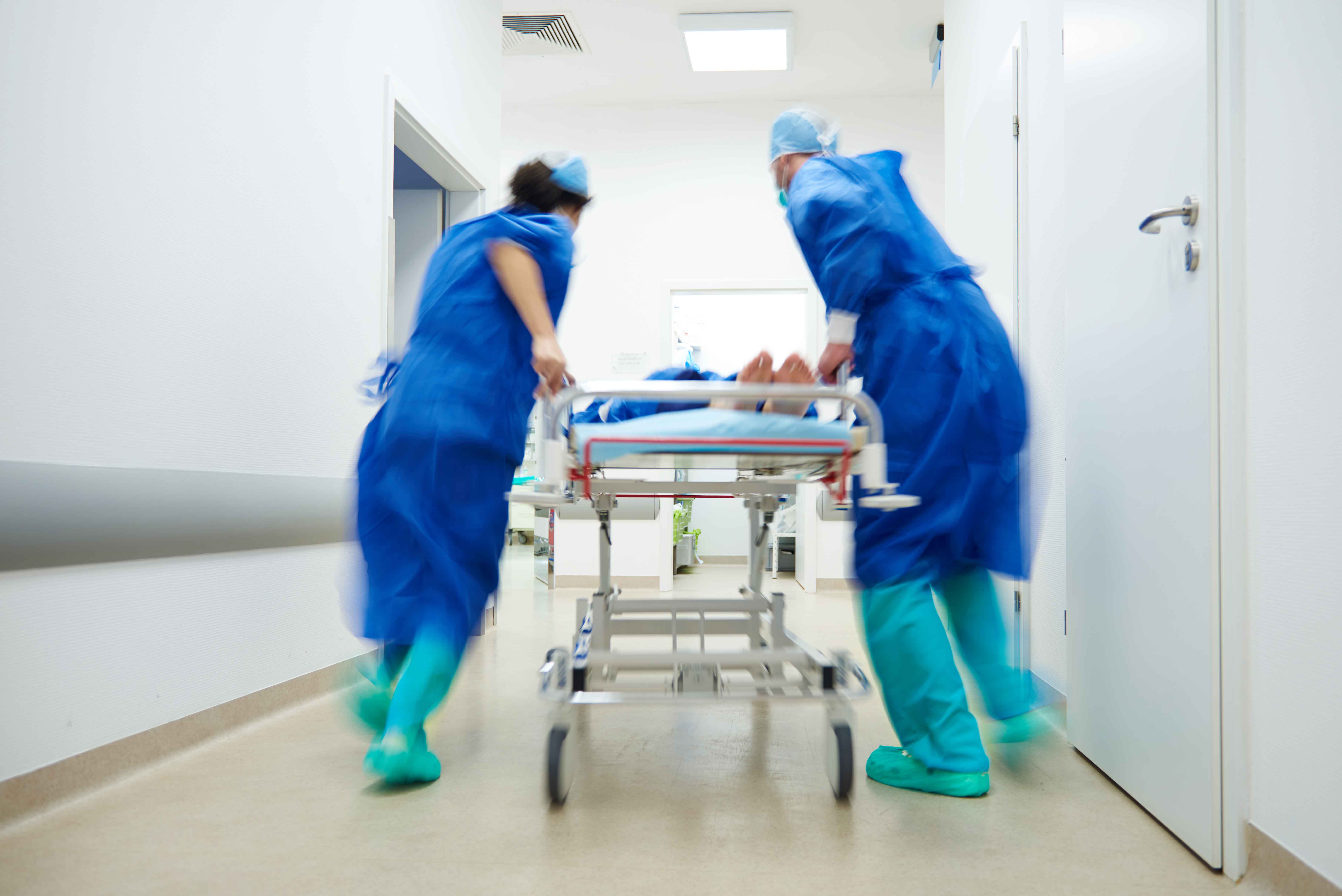 Doctores llevando paciente en camilla por pasillo